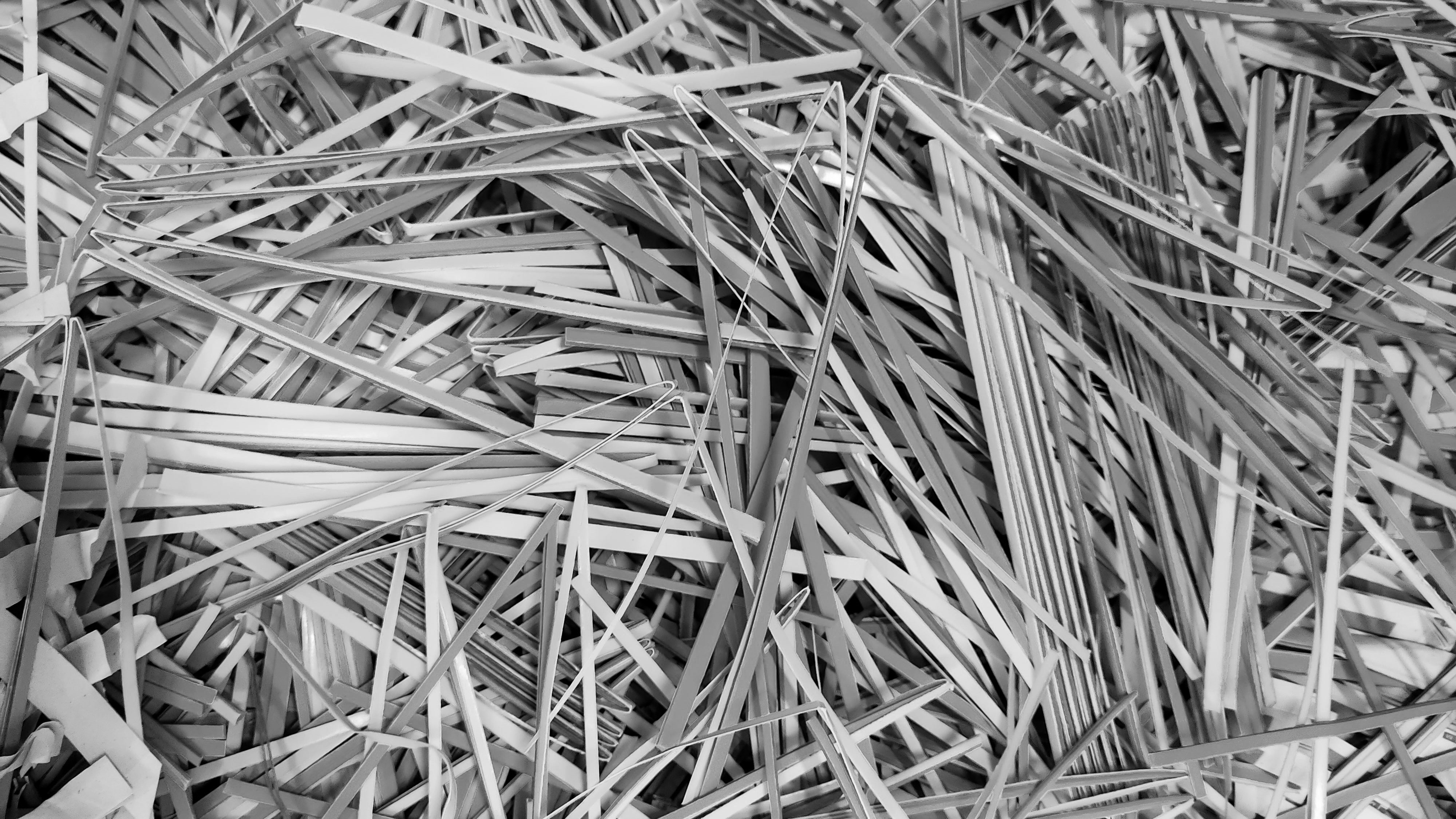 Close-up heap of thin shredded paper strips tangled together in grayscale. Photographer: Sobuj Ahamed