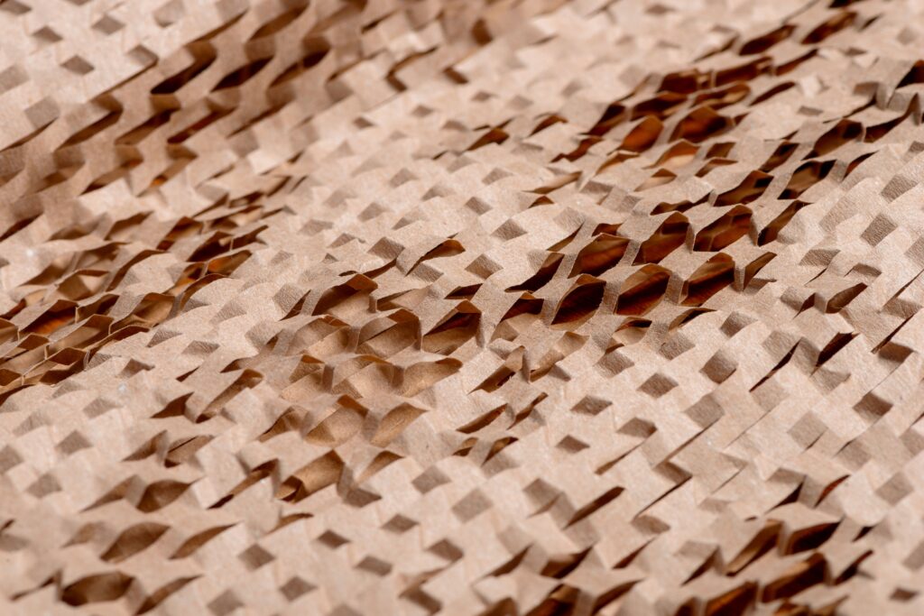 Detailed view of an intricate, textured brown paper pattern with cut-out layers. Photographer: Júlio Riccó