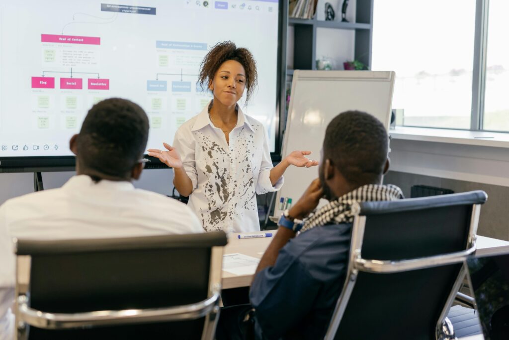 A woman leads a team meeting in a modern office using digital presentations. Photographer: Mikhail Nilov
